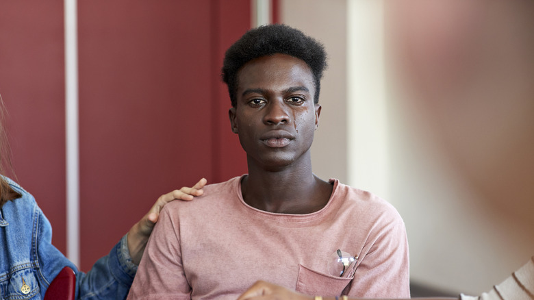 Une personne pleure tout en étant réconforté