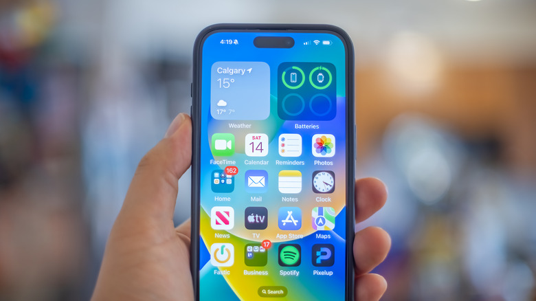 Une main tenant un iPhone 15 Plus