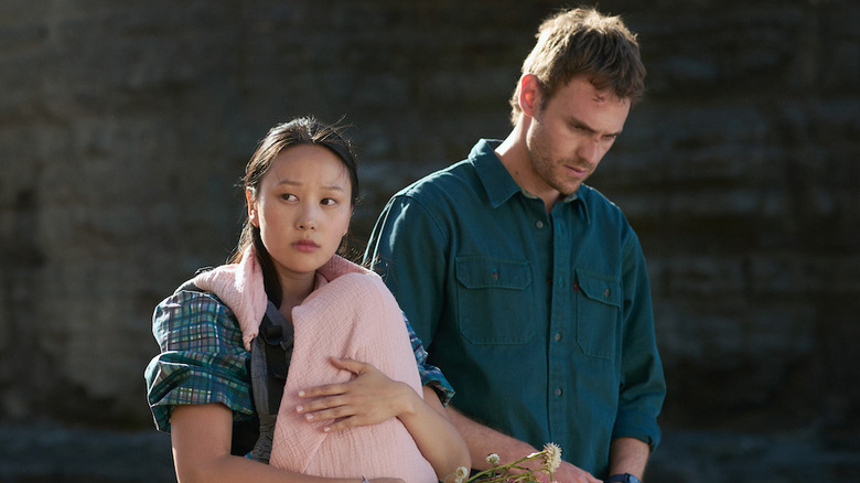 Charlie et Mia sur une plage avec leur bébé dans les survivants