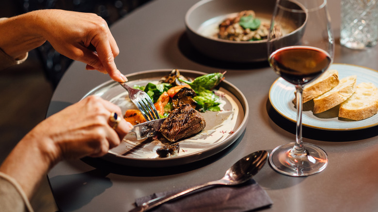 Quelqu'un mange avec un verre sur la table