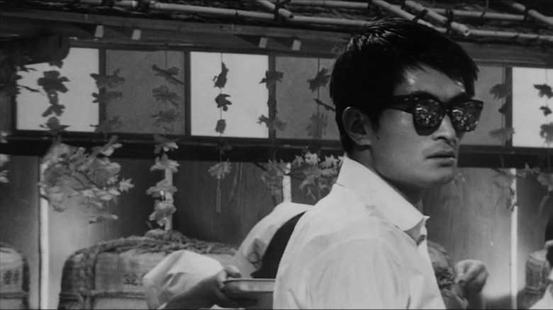 Tsutomu Yamazaki comme Ginjirô Takesuchi portant des lunettes de soleil en haut et bas