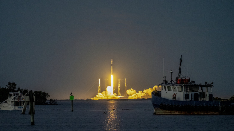 Une fusée SpaceX Falcon 9 se lance, éliminant les tours de la foudre au crépuscule