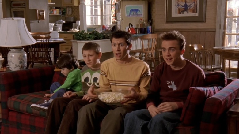 Les frères Jamie, Dewey, Reese et Malcolm sont assis sur le canapé en regardant la télévision dans un mélange de crainte et d'horreur 