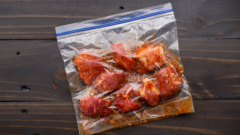 La viande se trouve dans un sac Ziploc sur une surface en bois