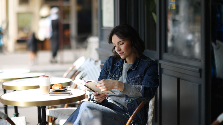 Femme Lire livre dans un café