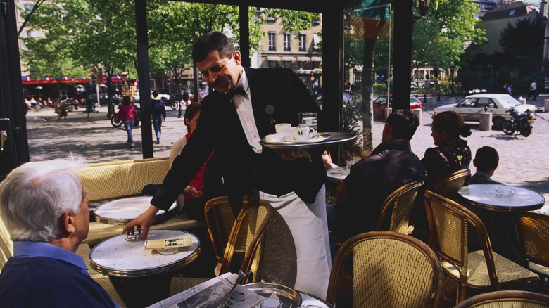 une personne qui lis le journal dans une table de café