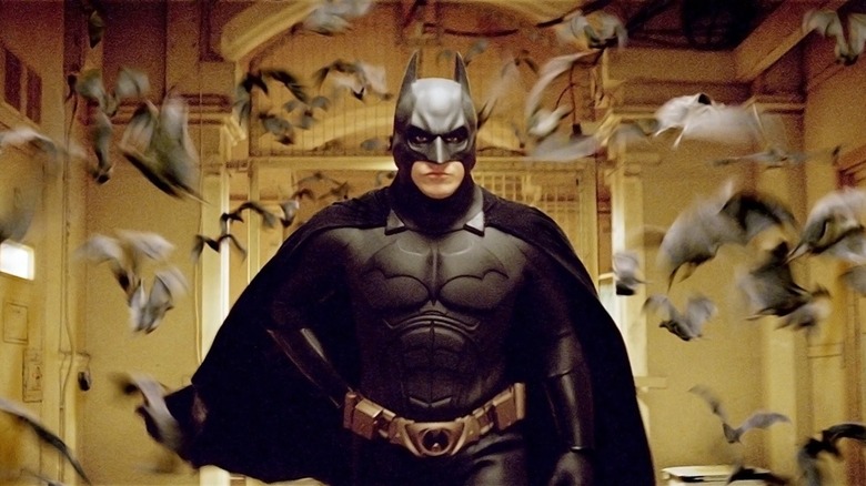 Christian Bale en tant que Batman entouré de chauves-souris à Batman commence