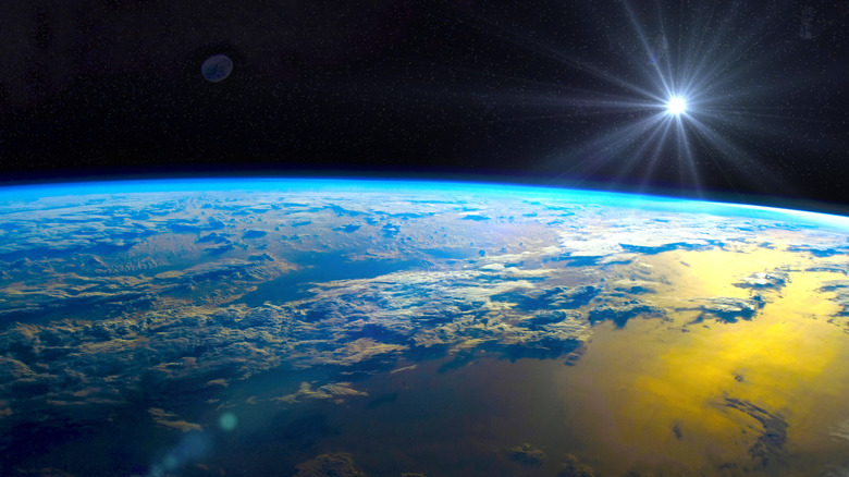 La surface de la terre vue de l'espace avec le soleil au loin