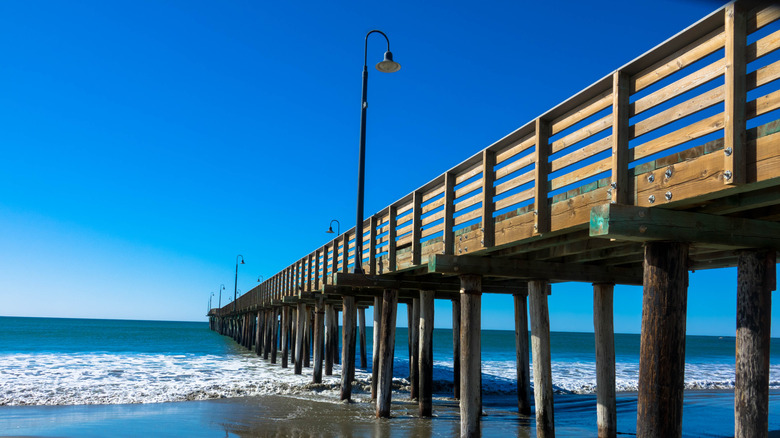 La jetée historique de Cayucos en bois pénétrant dans la baie d'Estero à Cayucos State Beach à Cayucos, San Luis Obispo County, Californie