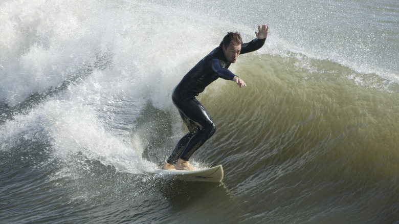 Un homme surfait au large des rives extérieures