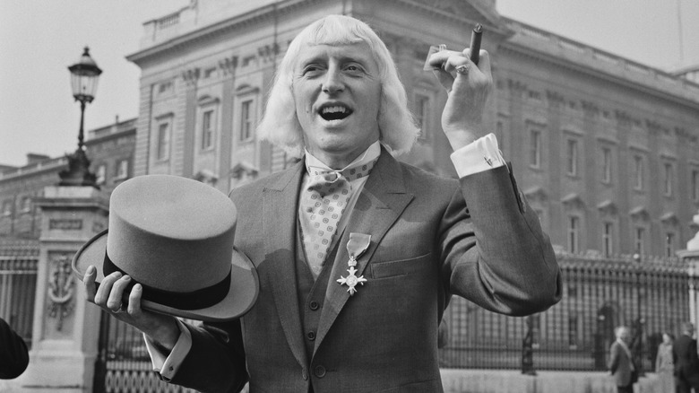 Jimmy Savile à l'extérieur du palais de Buckingham