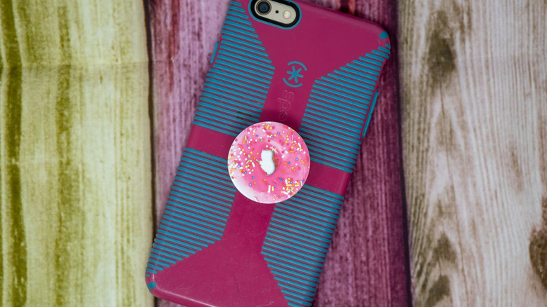 Donut rose à pied à l'arrière du téléphone