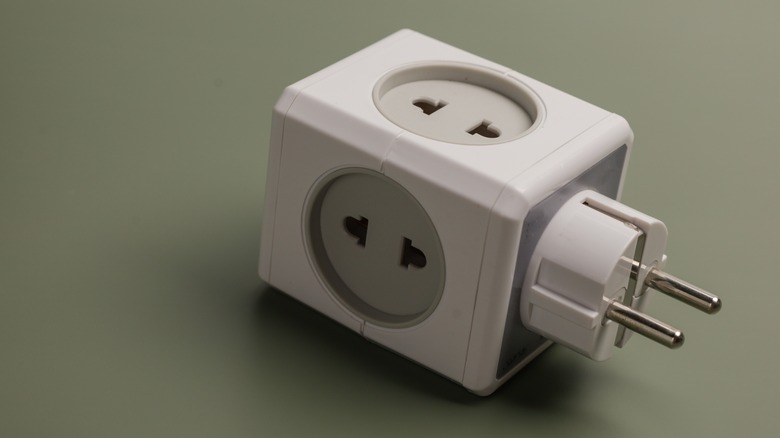 Un adaptateur électrique est affiché sur un fond vide