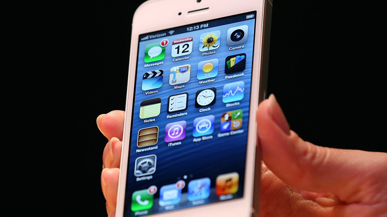 Une personne tenant un iPhone 5.