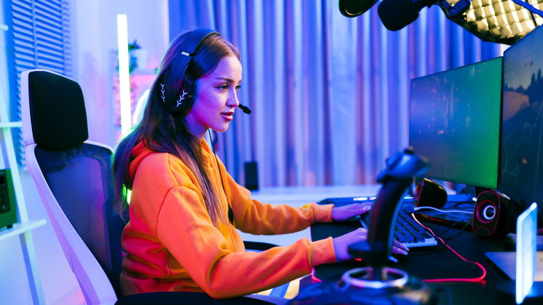 Quelqu'un qui joue dans une configuration PC à double moniteur, y compris les périphériques.