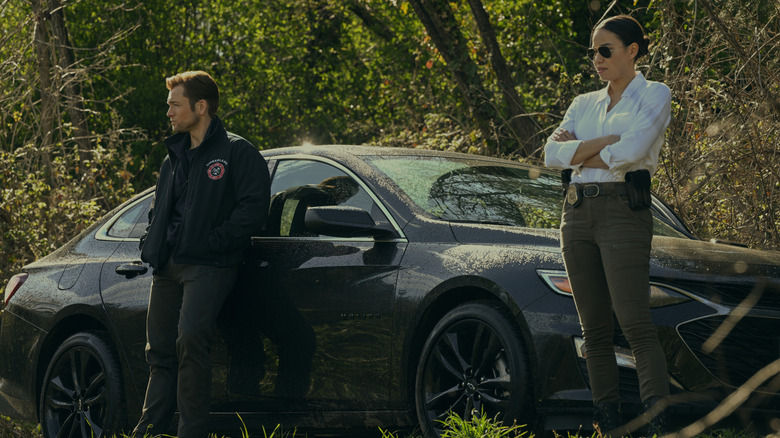 Dave et Michell se tenant près d'une voiture dans les bois sur la fumée