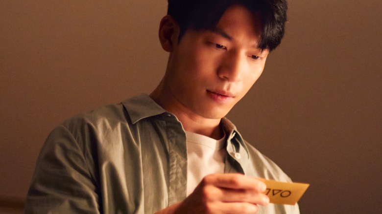 Jun-ho trouvant la note attachée au joueur 222 (l'enfant) dans le jeu de squid