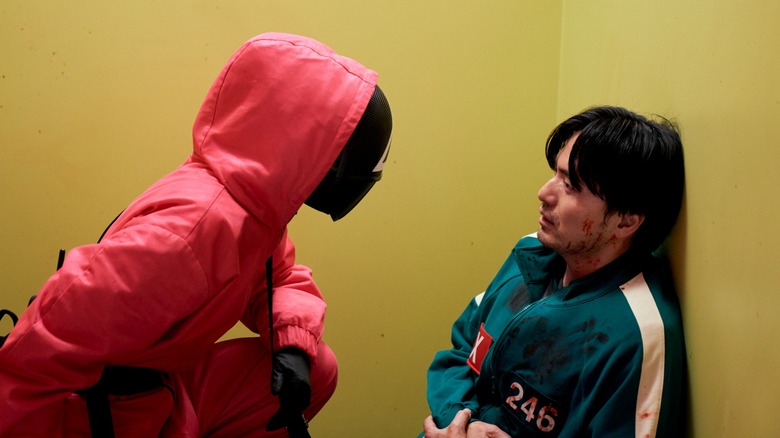 Garde 011 exhortant le joueur 246 à jouer à mort dans la saison 3 de Squid Game