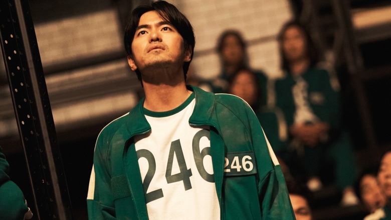 Joueur 246 Regardant le prix Piggy Bank in Squid Game