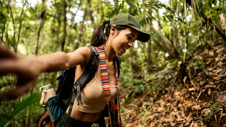 Jeune femme touristique faisant de la randonnée sur la forêt