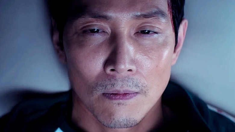 Lee Jung-jae en tant que Seong Gi-Hun avec les yeux à moitié ouverts sur le jeu Squid