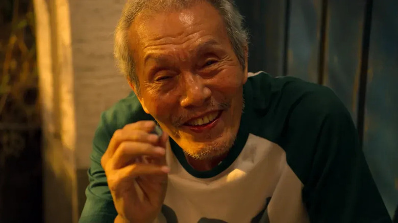 O yeong-su comme oh il-nam souriant sur le jeu de calmar