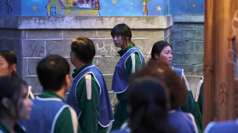 Park Sung-Hoon comme Cho Hyun-Ju portant un gilet bleu sur le jeu Squid