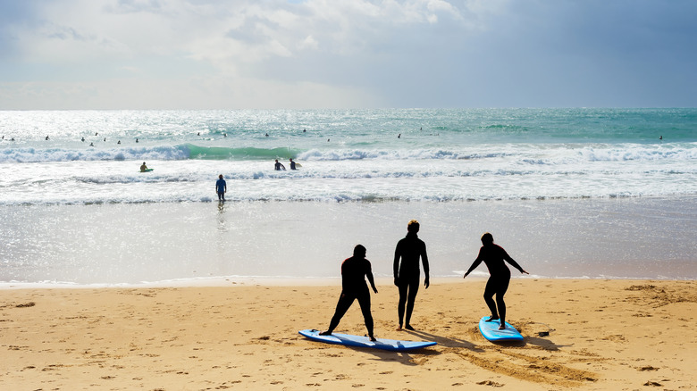 Deux personnes prenant une leçon de surf avec l'instructeur