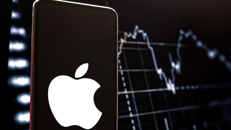 Logo iPhone sur un écran de smartphone au premier plan, stock d'image en arrière-plan en arrière-plan