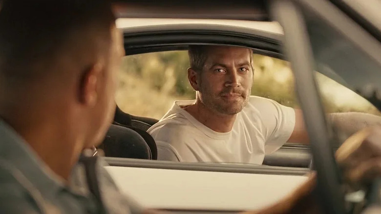 Brian sourit à Dom à travers la fenêtre de sa voiture dans Furious 7