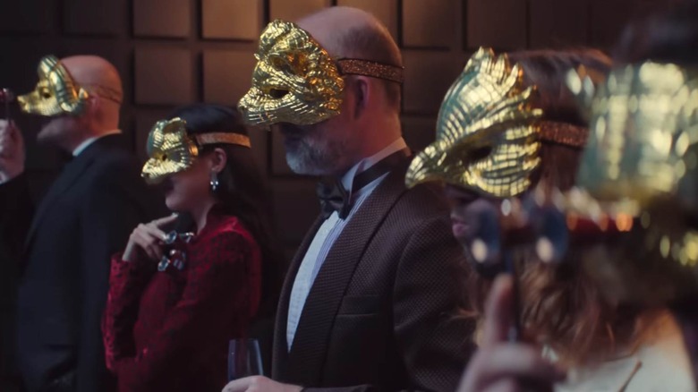 Squid Game VIPS dans une rangée en regardant quelque chose