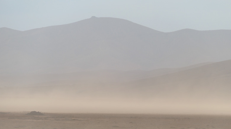 Une tempête de poussière se lance devant les montagnes