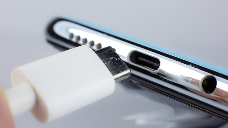 Un connecteur USB-C est sur le point d'être branché sur un smartphone.