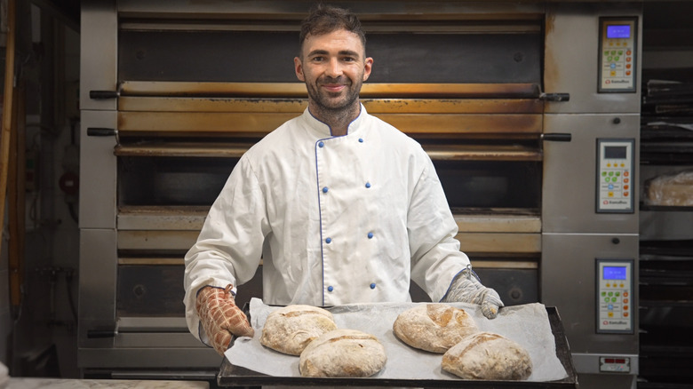 Un boulanger sortant du pain fraîchement cuit du four.