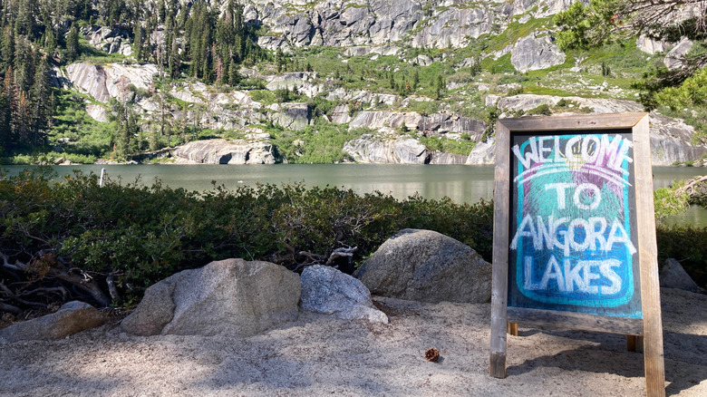 Signe de bienvenue tableau de tableau avec des falaises de lac et de granit en arrière
