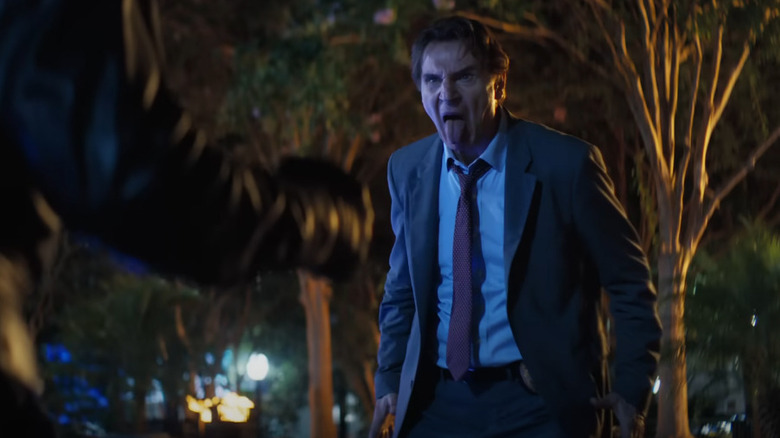 Liam Neeson en tant que Frank Drebin qui sort sa langue tout en affrontant un criminel dans un parc la nuit dans le pistolet nu (2025)