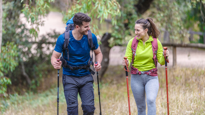 Couple de randonnée avec des poteaux