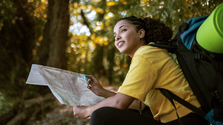 femme utilisant une carte sur un sentier de randonnée