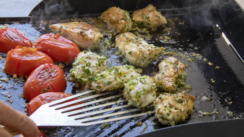 Tomates et poulet assaisonné sur une plaque chauffante