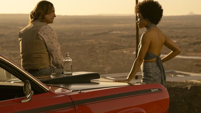 Josh Holloway en tant que Jim Ellis assis sur le capot de son Duster rouge tandis que Rachel Hilson alors que Nina Hayes se tient à proximité dans la finale de la saison de Duster