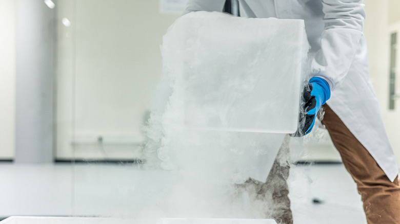 Un scientifique manipulant une baignoire de glace sèche