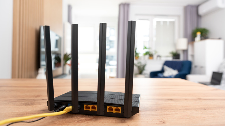 Un routeur Wi-Fi avec une maison en arrière-plan.