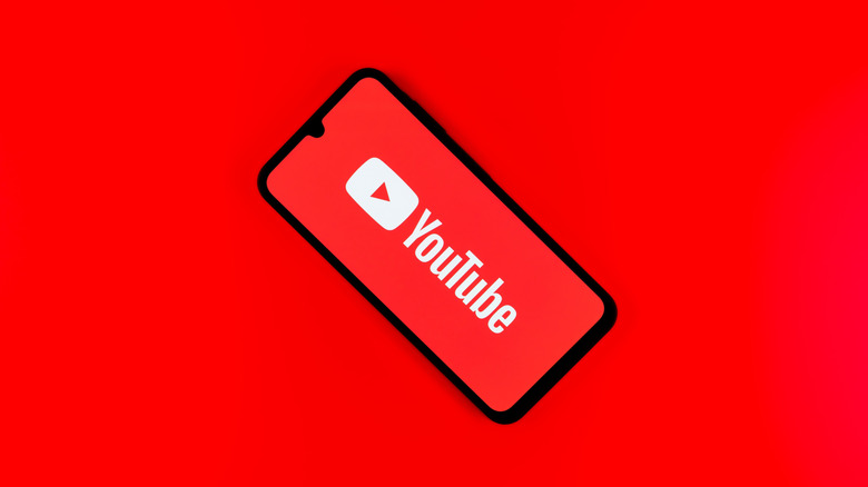 Le logo YouTube sur un téléphone, réglé sur un fond rouge.