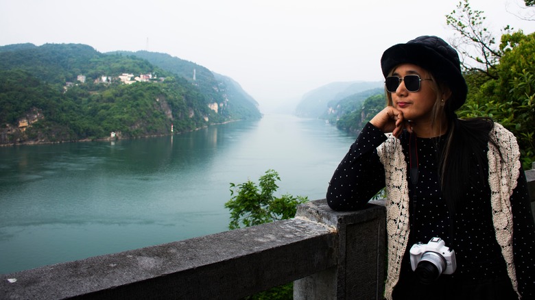 Un voyageur pose sur le bord d'un mur à côté de la rivière Yangtze, en Chine,