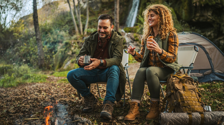 Un couple assis dans un camping dans les bois.