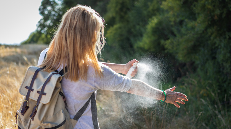 Une randonneur applique un insecte et un baleine à cocher sur son bras.