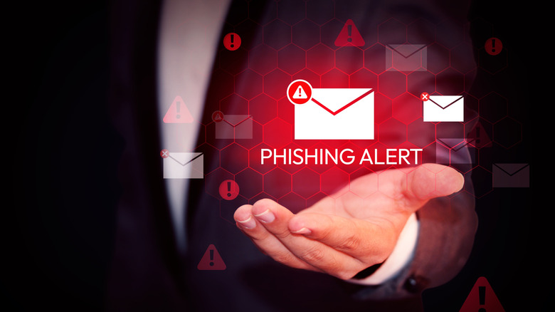 Un message d'alerte de phishing rougeoyant rouge planant sur une main.
