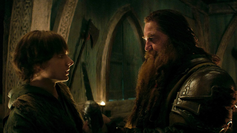 Hiccup regardant son père Stoick le vaste à l'intérieur d'une salle viking dans How to Train Your Dragon