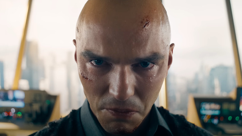 Gros plan de Lex Luthor avec des coupes et des ecchymoses sur son visage grimaçant dans le bâtiment Luthorcorp à Superman