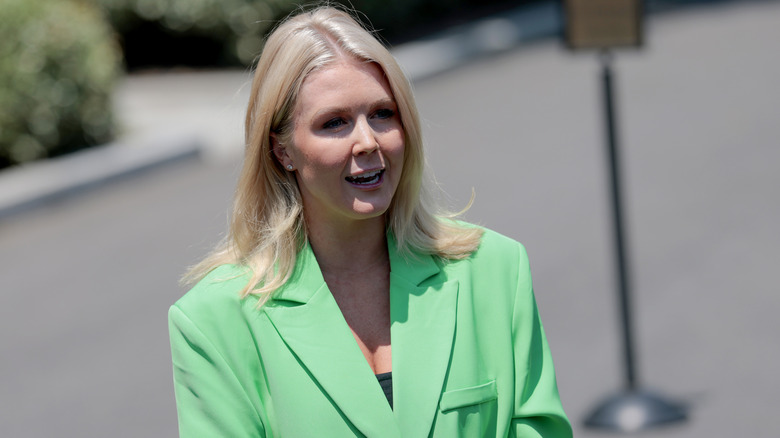 Karoline Leavitt dans un blazer vert tout en parlant dehors